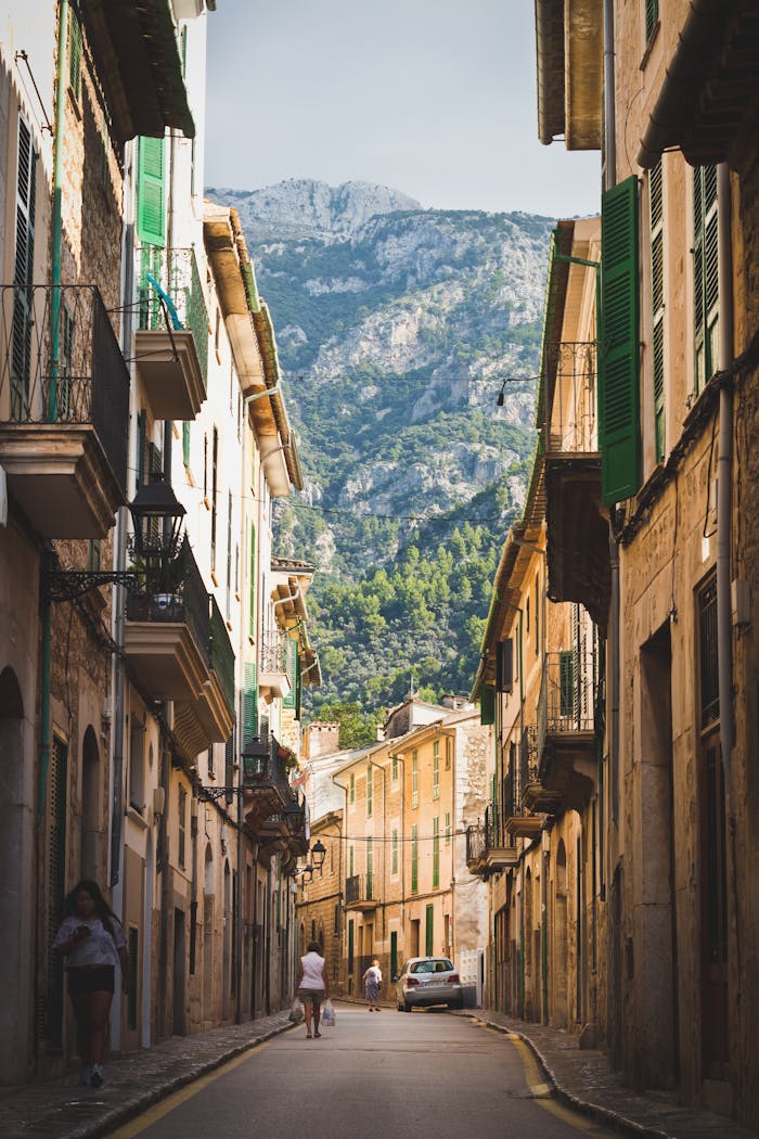 Discover the picturesque streets of Sóller, Spain with beautiful mountain backdrops and historic architecture.